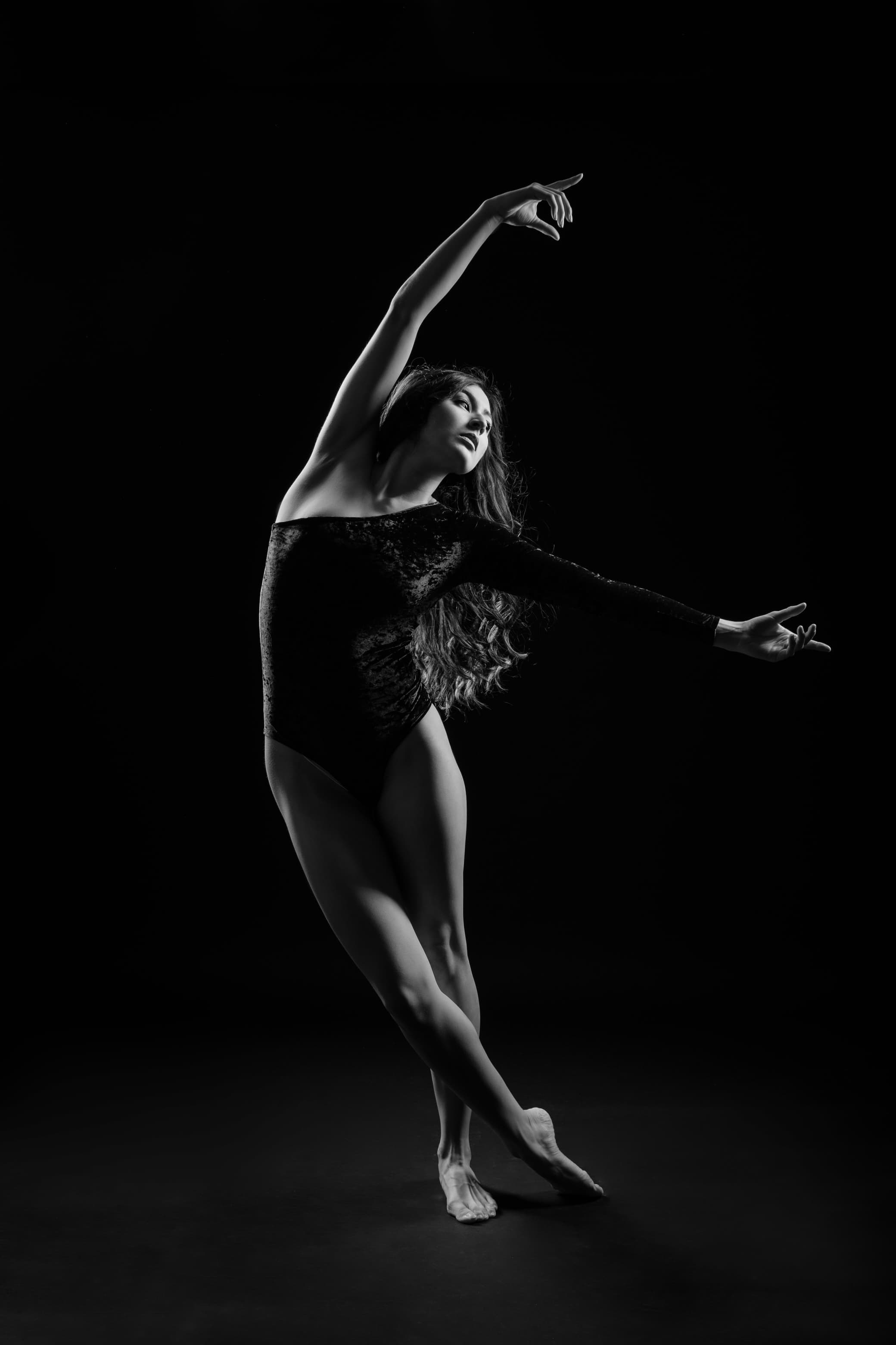 Mae mid-dance move, a black-and-white silhouette with her arm raised in a fluid motion.